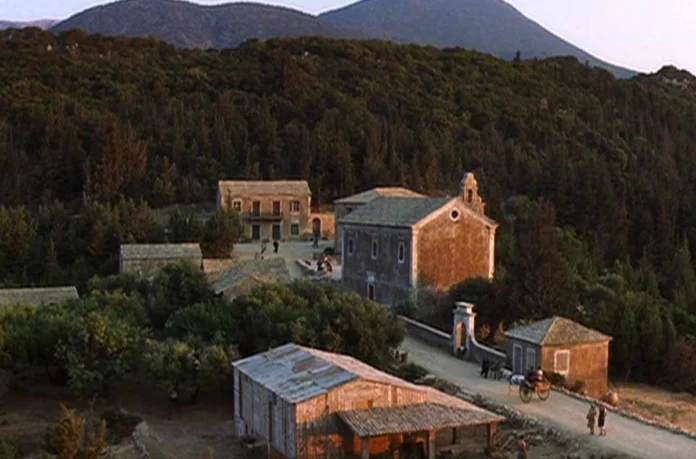 The ruined stone houses of Old Vlachata village in Kefalonia, with roofless structures and overgrown greenery, used as a filming location for Captain Corelli's Mandolin.