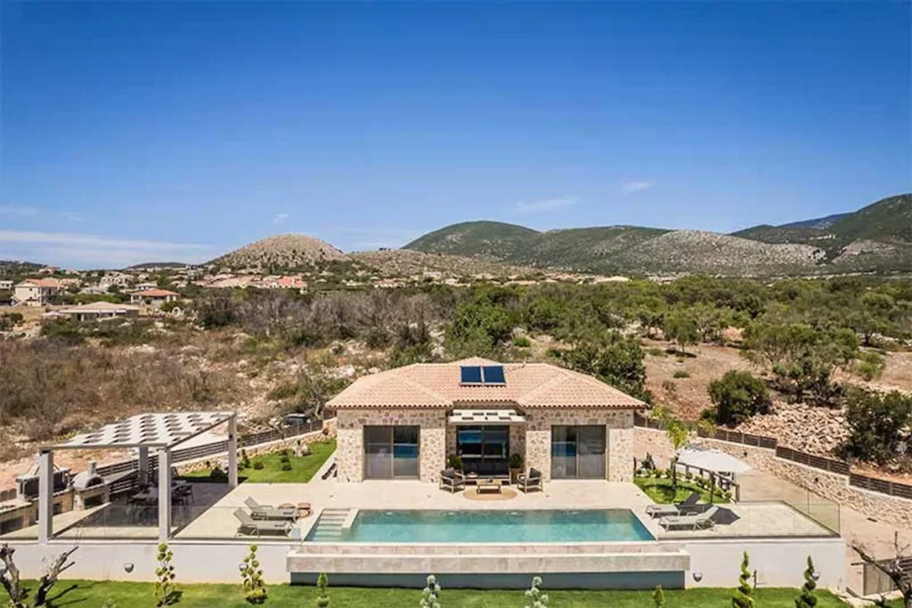 A modern Greek villa featuring a clean-lined swimming pool and a paved terrace near the Ionian Sea.