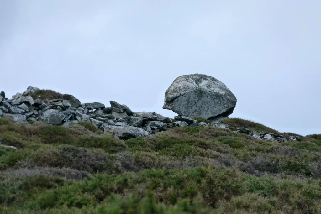A large, naturally rounded rock formation resembling a modern sculpture in the remote Polemou Kambos region of Tinos Island, Greece.
