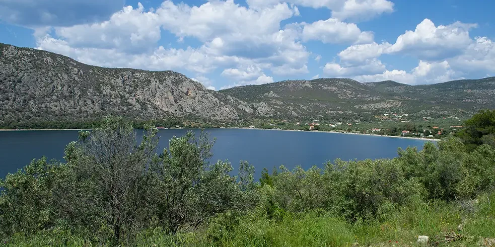 Panoramic view of the Heraion Lagoon in Loutraki, Corinthia, showing the calm blue water and coastal landscape of mainland Greece.