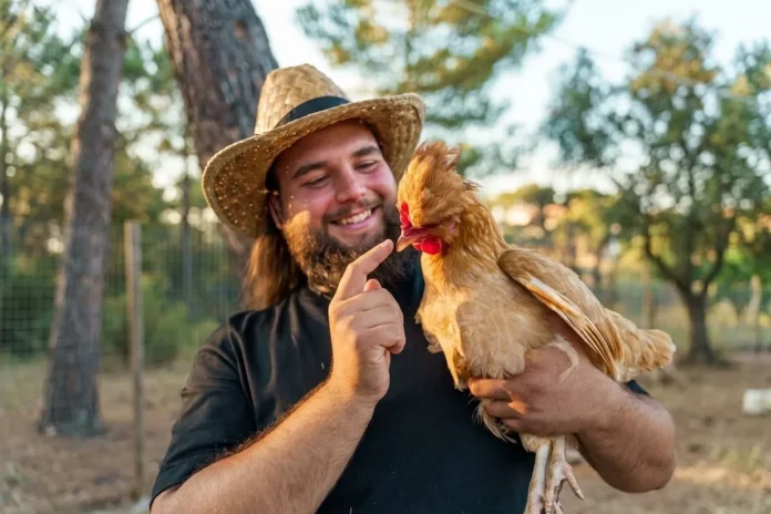 Thanassis Kallinteris holding a chicken in his garden in Greece