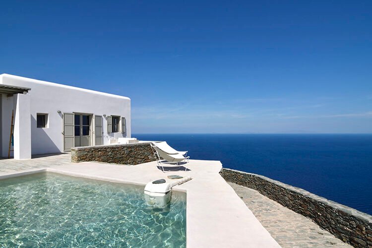 A modern uphill villa in Corinthia featuring pool with an unlimited view of the sea and sky, representing luxury real estate investment in Greece.