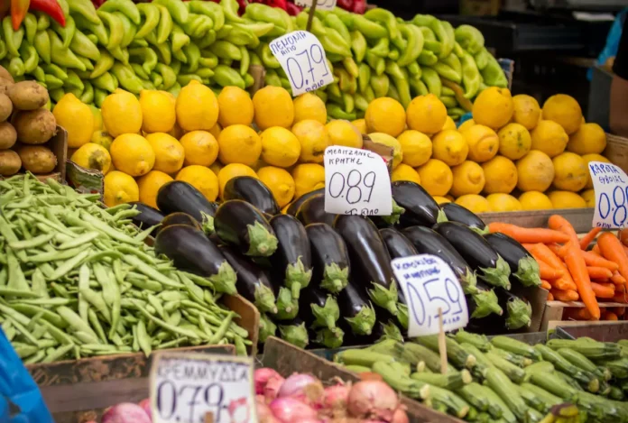 A shot of vibrant, of deep purple eggplants and lemons at a Greek street market.