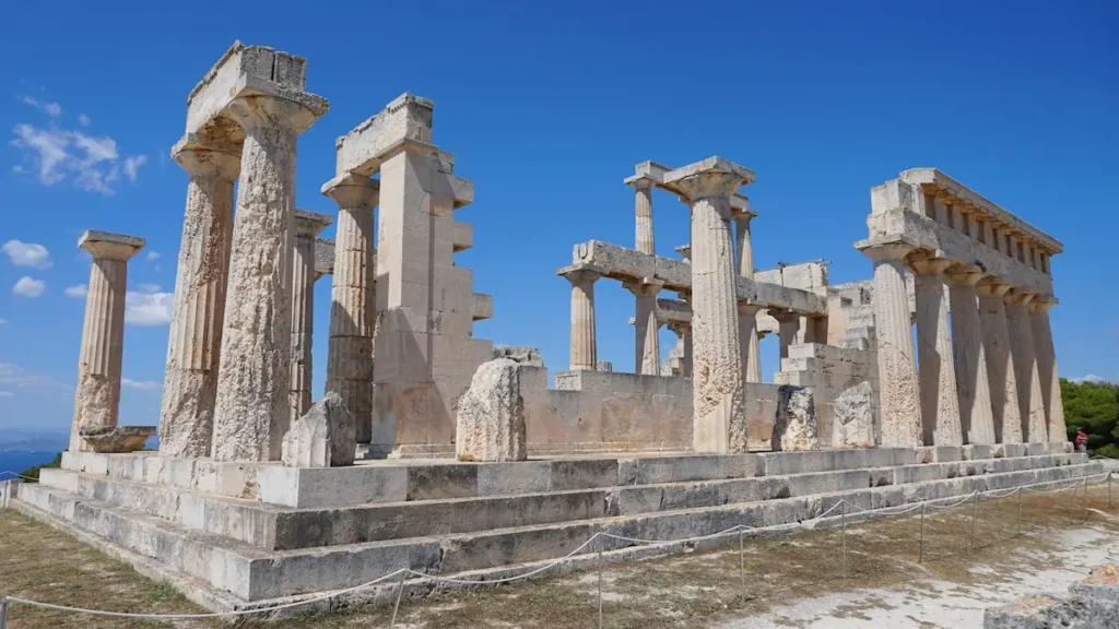 Detail shot of the well-preserved Doric columns of the Temple of Aphaia under a bright Greek sky.