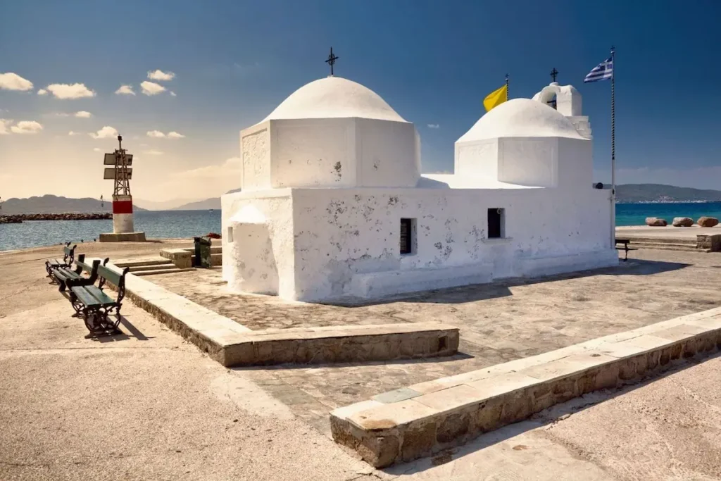 The small 17th-century white chapel of Agios Nikolaos Thalassinos with two domes at the entrance of Aegina harbor.