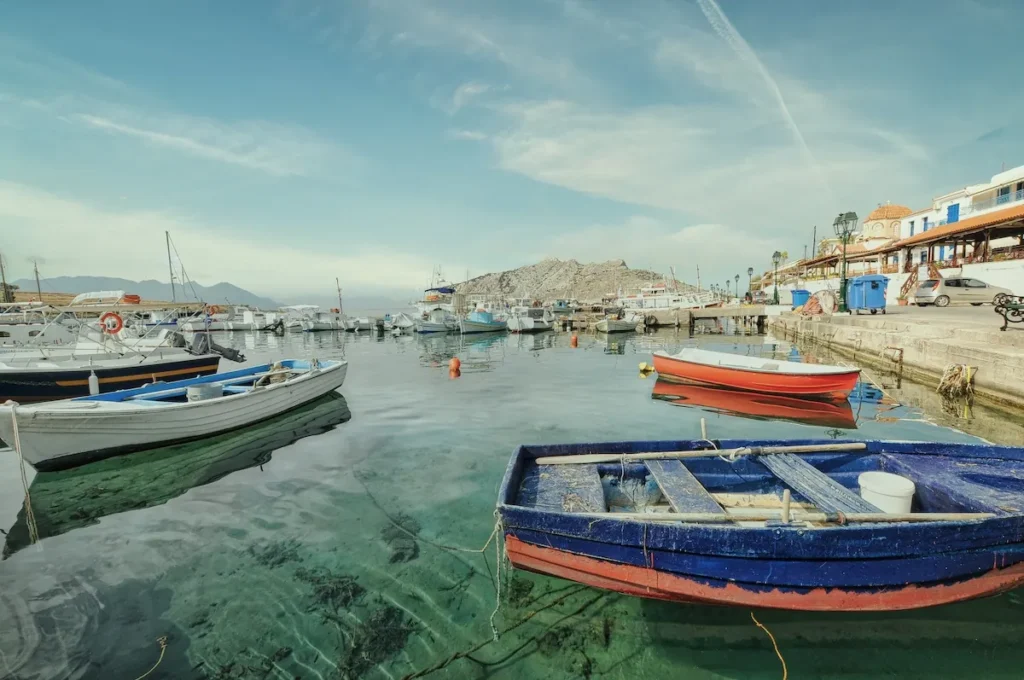 Colorful traditional Greek wooden fishing boats (kaikia) moored in Perdika harbor.