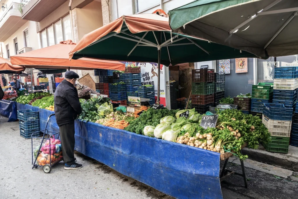 Unlike the seasonal markets of smaller islands, Kalamata’s market is a permanent, sophisticated infrastructure. This shot of the butcher shops and the central square illustrates the city’s ability to provide fresh, healthy, and affordable Mediterranean staples throughout all four seasons.
