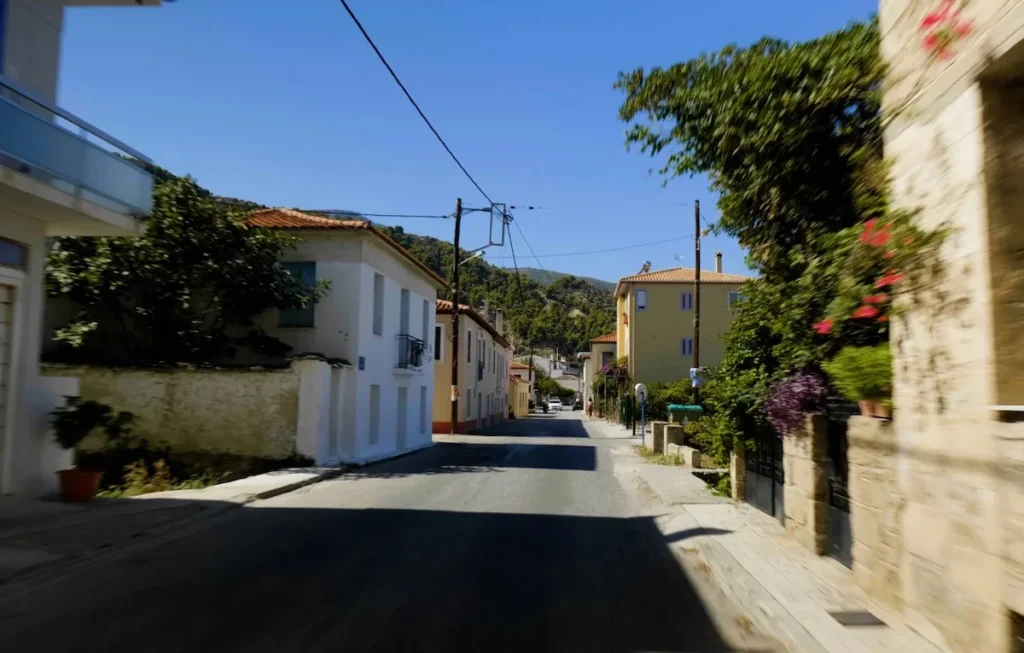 A peaceful street view in Derveni with long shadows and a calm, quiet atmosphere.
