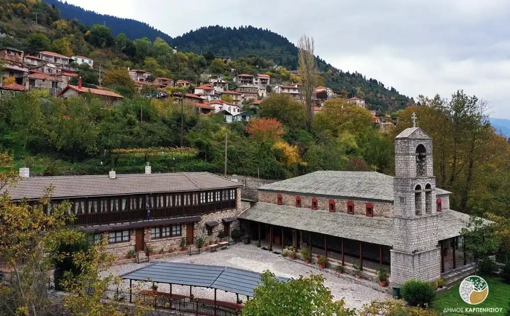 The historic stone Monastery of Moni Damianon overlooking a remote traditional village in the valley.