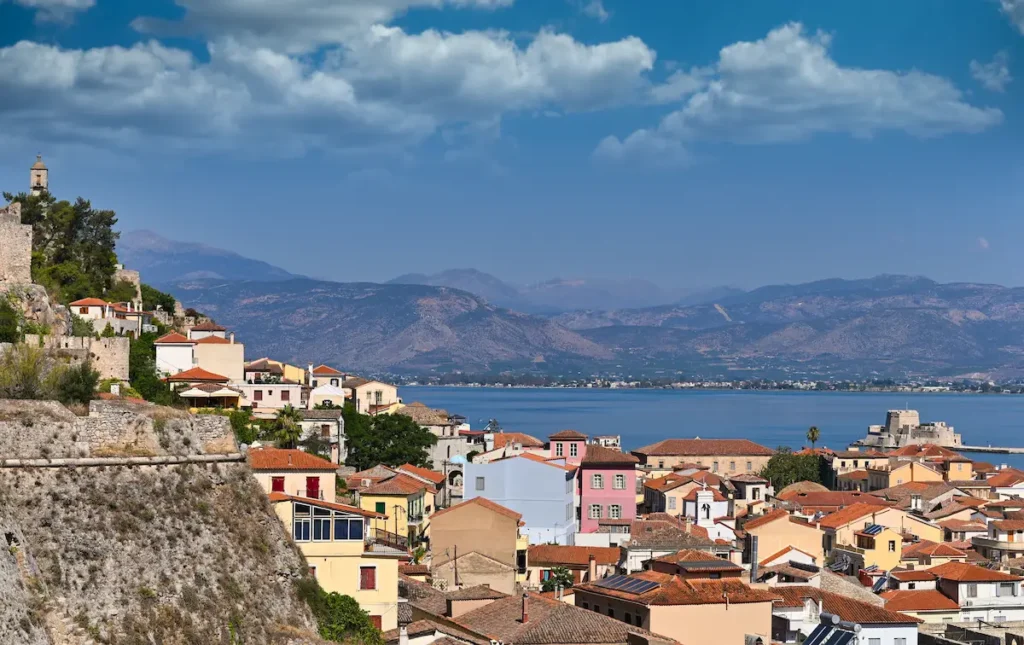A view across the terracotta rooflines of Nafplio with the greenery of Acronafplia in the background.