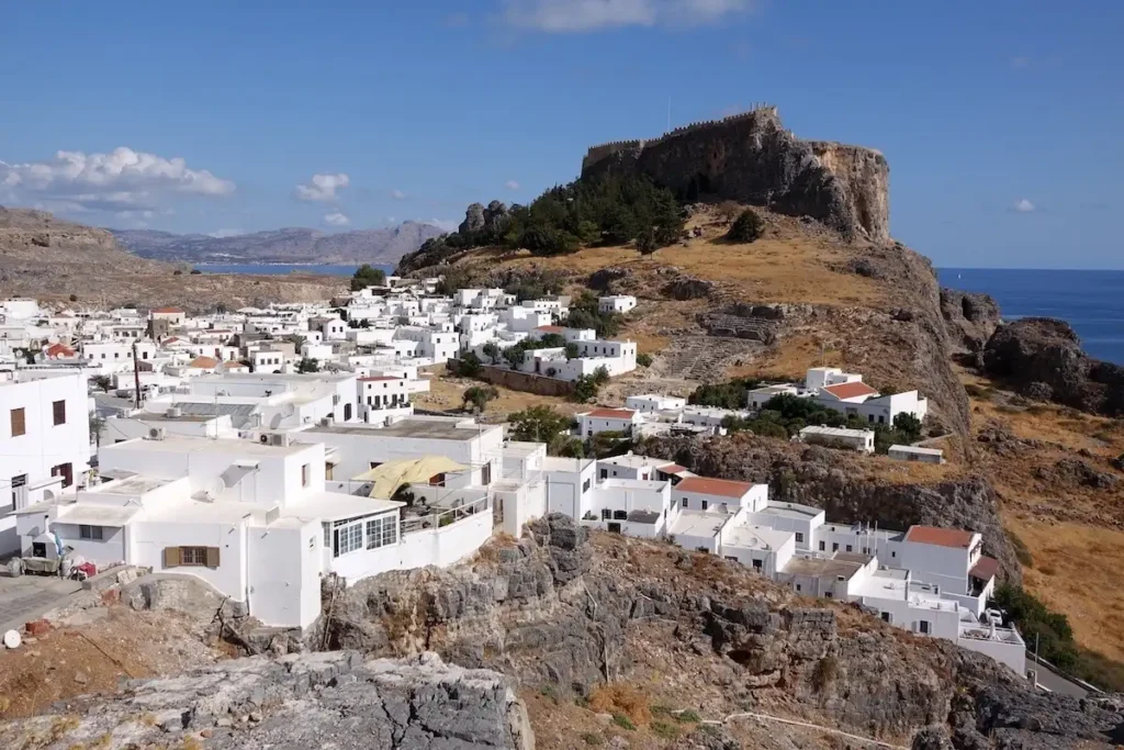 View of Lindos village with the ancient Acropolis standing on the cliff above the whitewashed houses.
