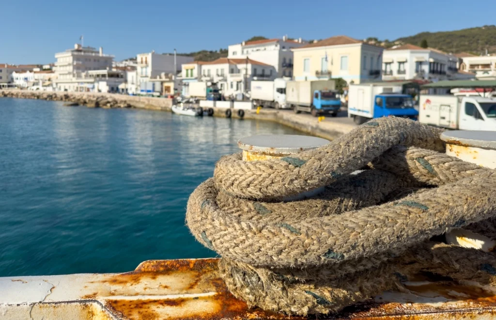 A macro shot of a thick, weathered mooring rope tied to a bollard at the quay.