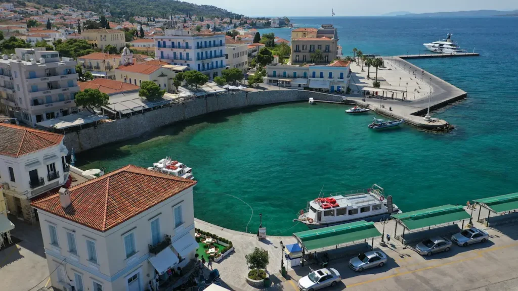 An aerial view of the Spetses Old Port (Palio Limani) with traditional boats and waterfront tavernas.