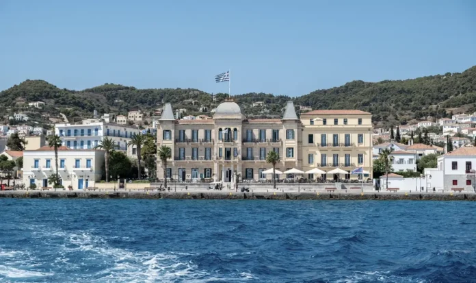 The grand neoclassical facade of the historical Poseidonion Grand Hotel by the Spetses waterfront.