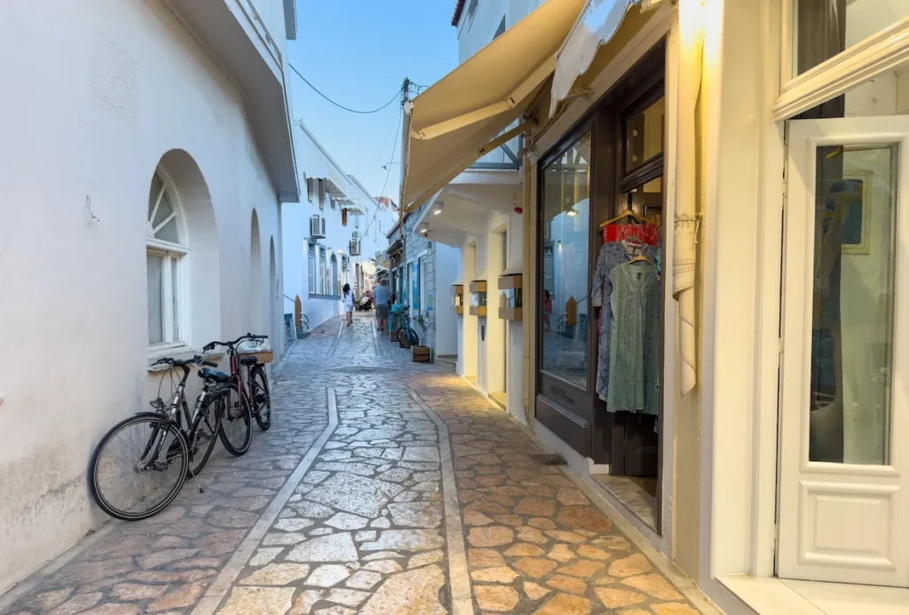 A quiet, narrow stone-paved street lined with local boutiques and shuttered windows.
