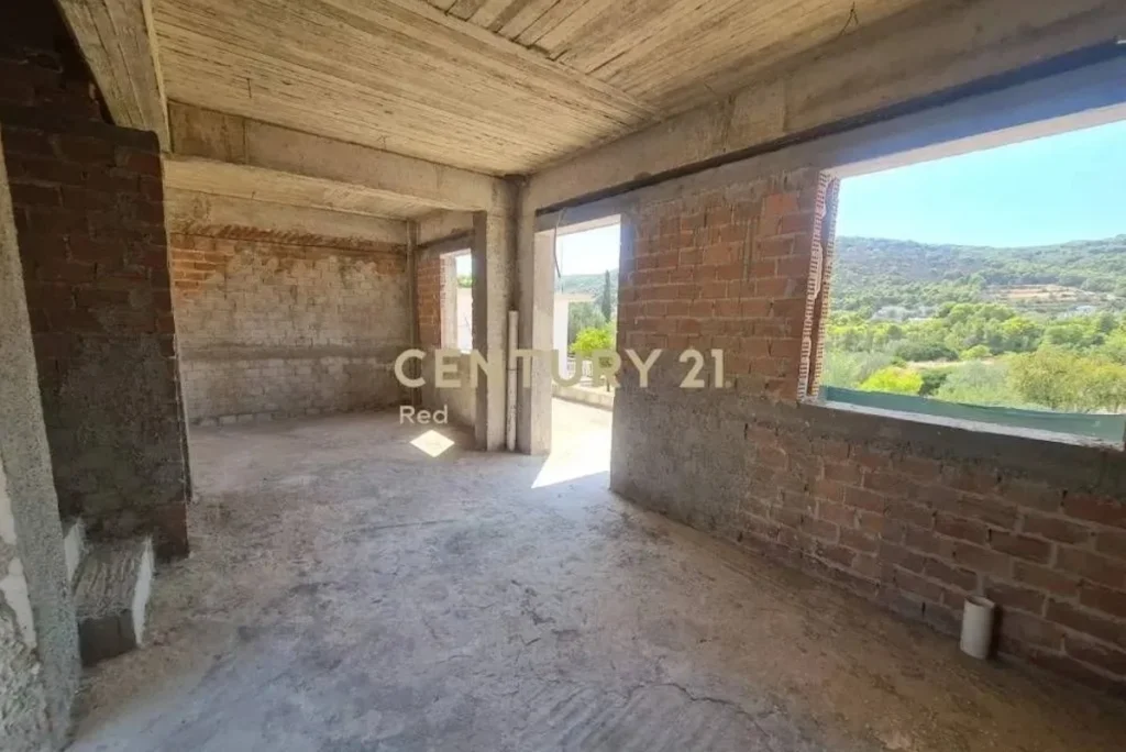 A construction-stage brick house in Messagros, Aegina, with windows overlooking the green Mediterranean landscape. Source: Spitogatos.