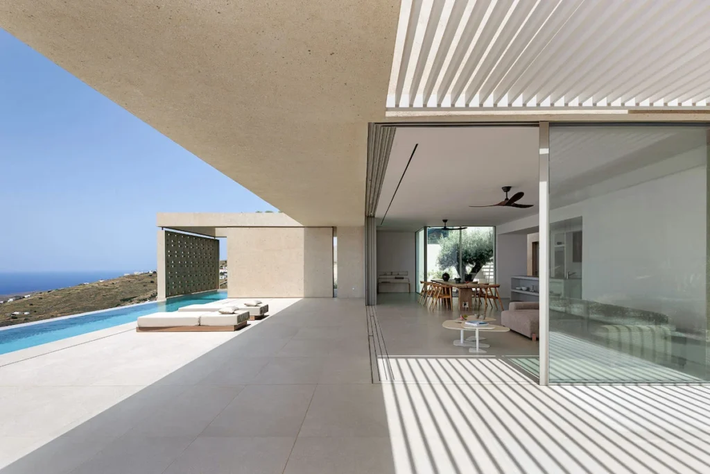 A modern semi-underground house integrated into a steep hillside on Tinos.