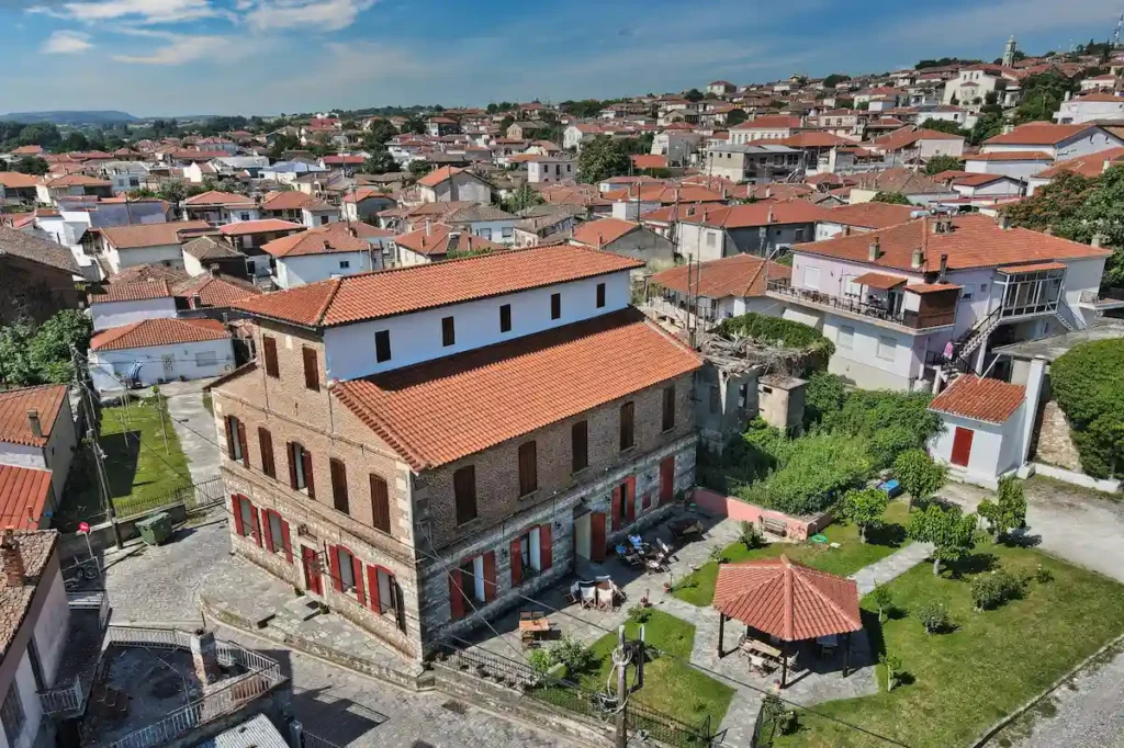 Restored 19th-century cocoon house operating as a municipal guesthouse in Soufli, with the town visible in the background in northeastern Greece.
