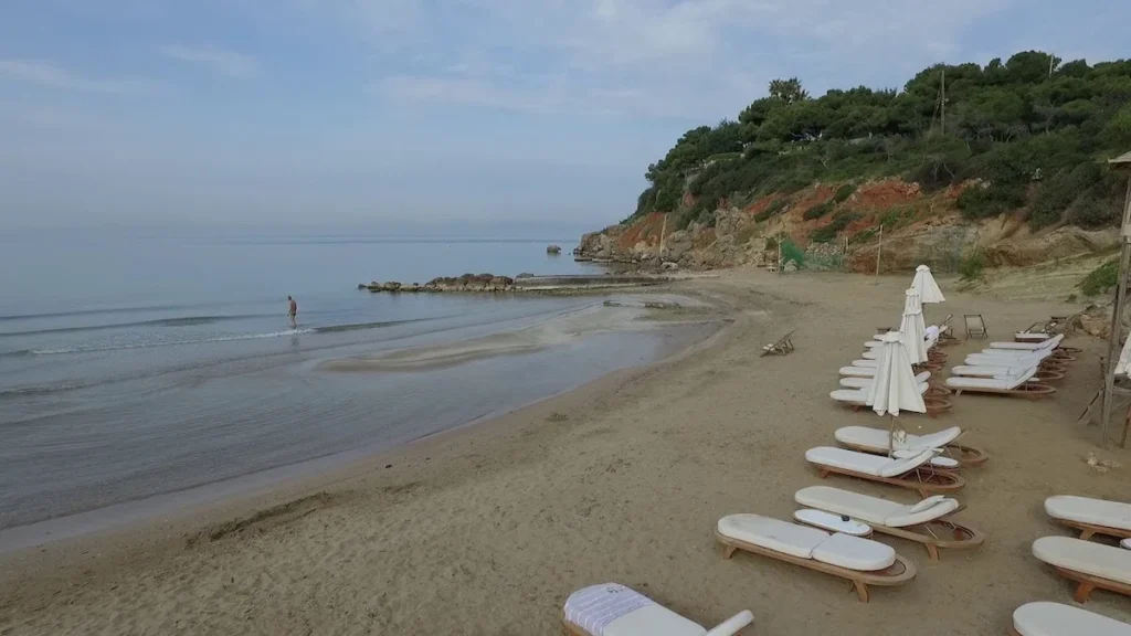 Wide shot of the golden sand beach in Vouliagmeni with turquoise waters, located a few kilometers from Athens.