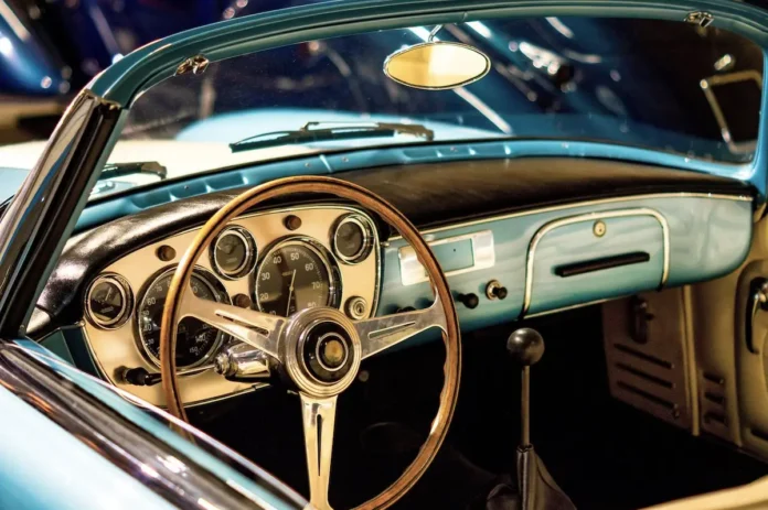 Interior of a vintage light blue Maserati convertible with classic dashboard and steering wheel