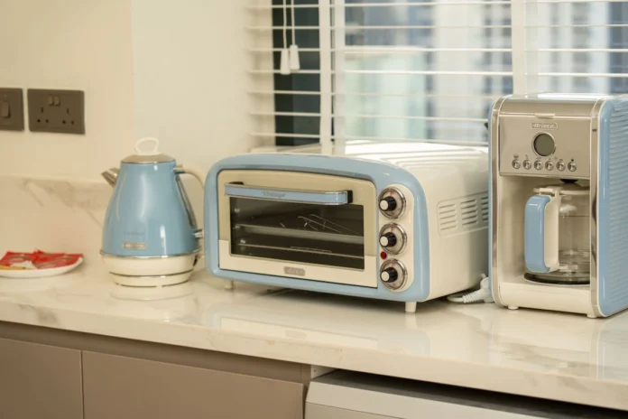 Retro-style small kitchen appliances with blue accents arranged on a modern countertop.