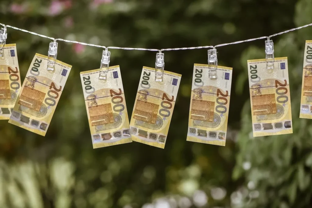 Two hundred euro banknotes hanging on a laundry string, illustrating concepts of bank checks and anti-money laundering measures.