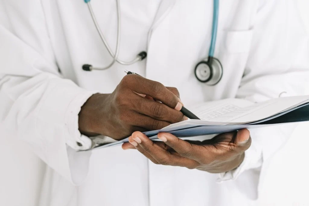 Doctor reviewing medical information on a clipboard during a consultation in a healthcare office.