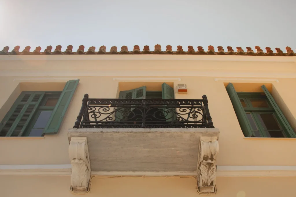 Close-up of a neoclassical balcony with ornate wrought iron railing in Athens