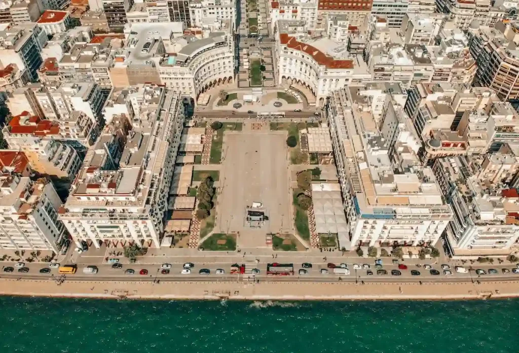 Aerial view of Aristotelous Square in Thessaloniki opening up to the sea, surrounded by grand neo-Byzantine architecture.