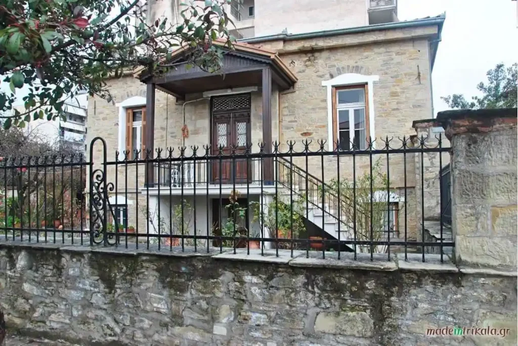 A restored stone mansion on Asklipiou Street displaying traditional wooden balconies and intricate architectural details.