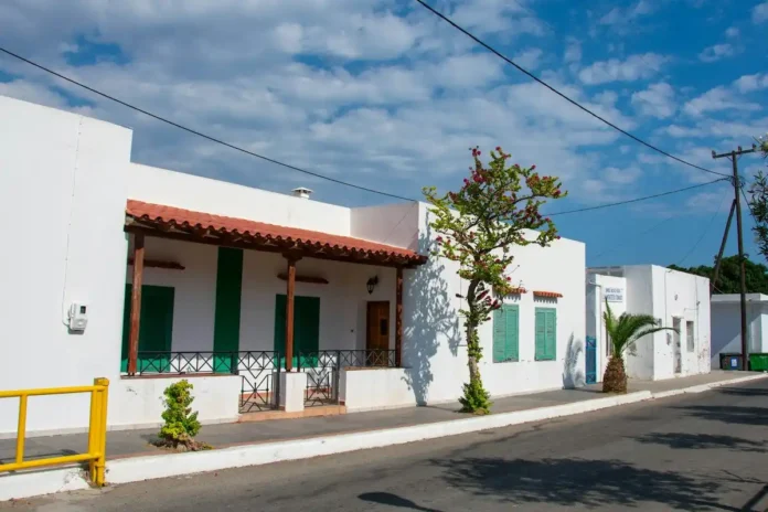 White one-storey houses with green window frames and doors in Rhodes, Greece