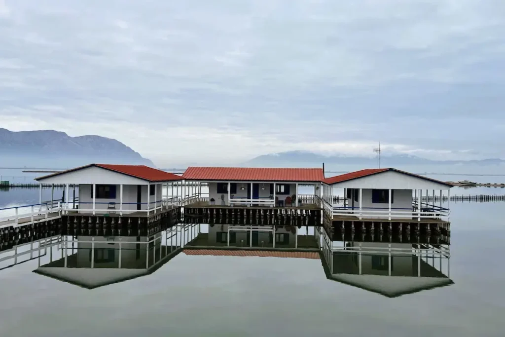 Three wooden pelades huts standing together in the lagoon