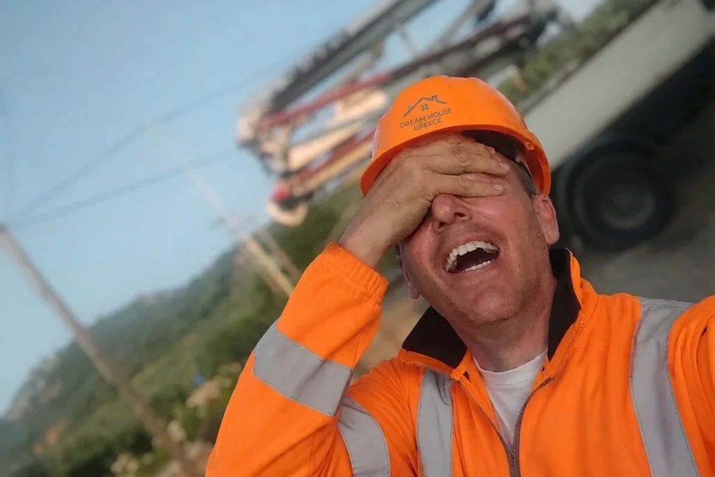 Maarten G. Verhoef, independent construction supervisor, laughing on a construction site with one hand covering his eyes.