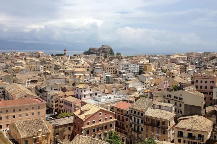Aerial view of Old Fortress Corfu and historic Corfu Town showing red tile roofs and ochre buildings.
