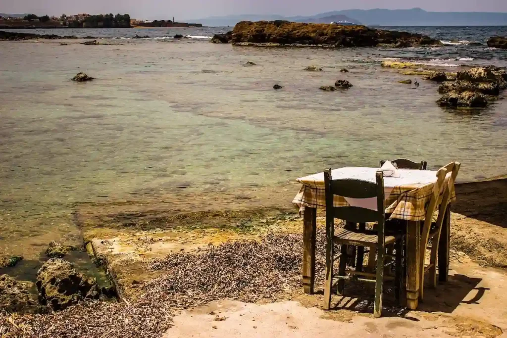 Empty table overlooking the water in Chania during the off-season.