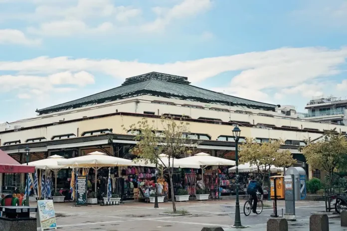 Exterior of Karditsa's old municipal market building, with a cyclist riding past