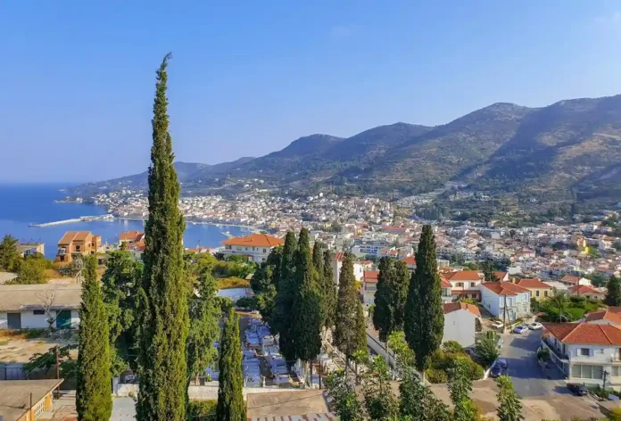 High-altitude aerial photograph of Samos island showing the coastline, deep blue sea, and mountainous terrain.