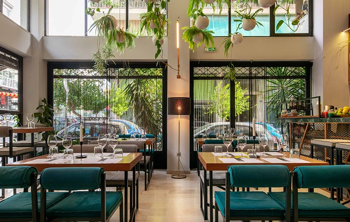 Interior of a modern café in Koukaki, showcasing a renewed industrial space. A modern café in Koukaki, representing the transformation of former warehouses and garages into new neighborhood spaces.