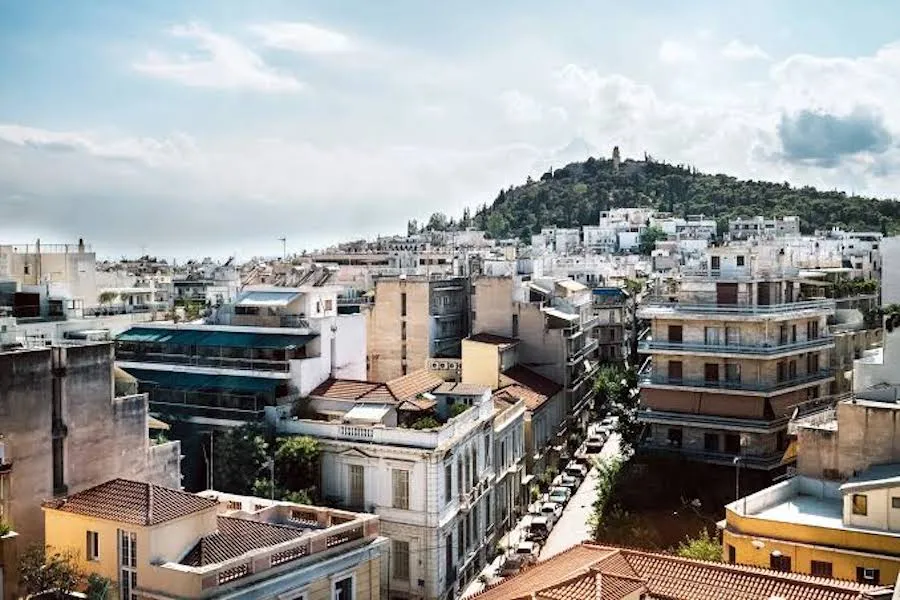 Street view in Koukaki showing a neoclassical building alongside 1970s apartment blocks.