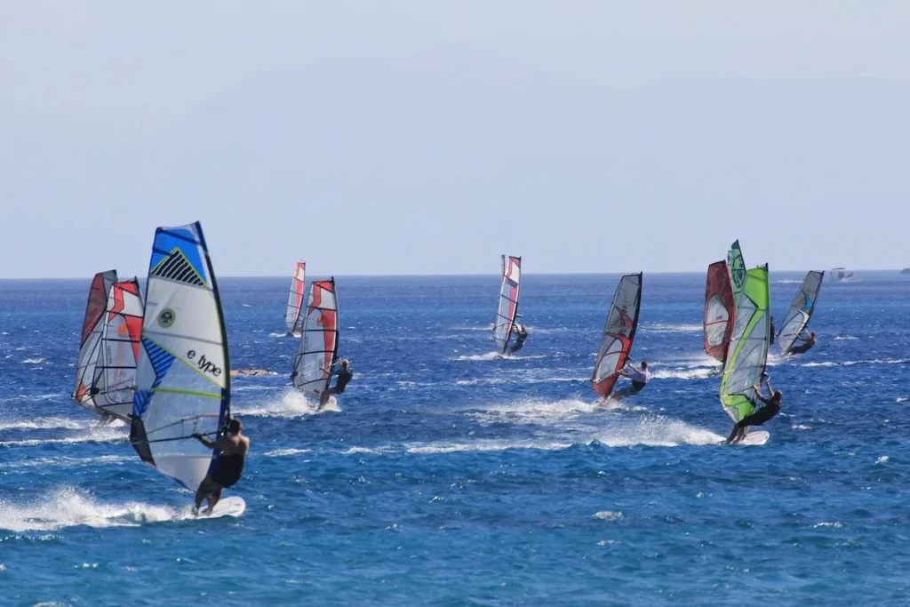 About a dozen windsurfers sailing on the water in Vasiliki Bay, Lefkada